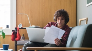 Ein junger Student prüft seine Optionen, um die Kosten für das Studium zu bezahlen.